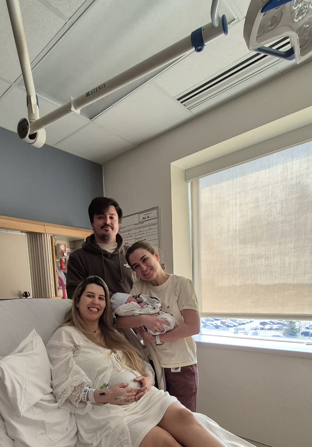 A family and doula together with a newborn in hospital
