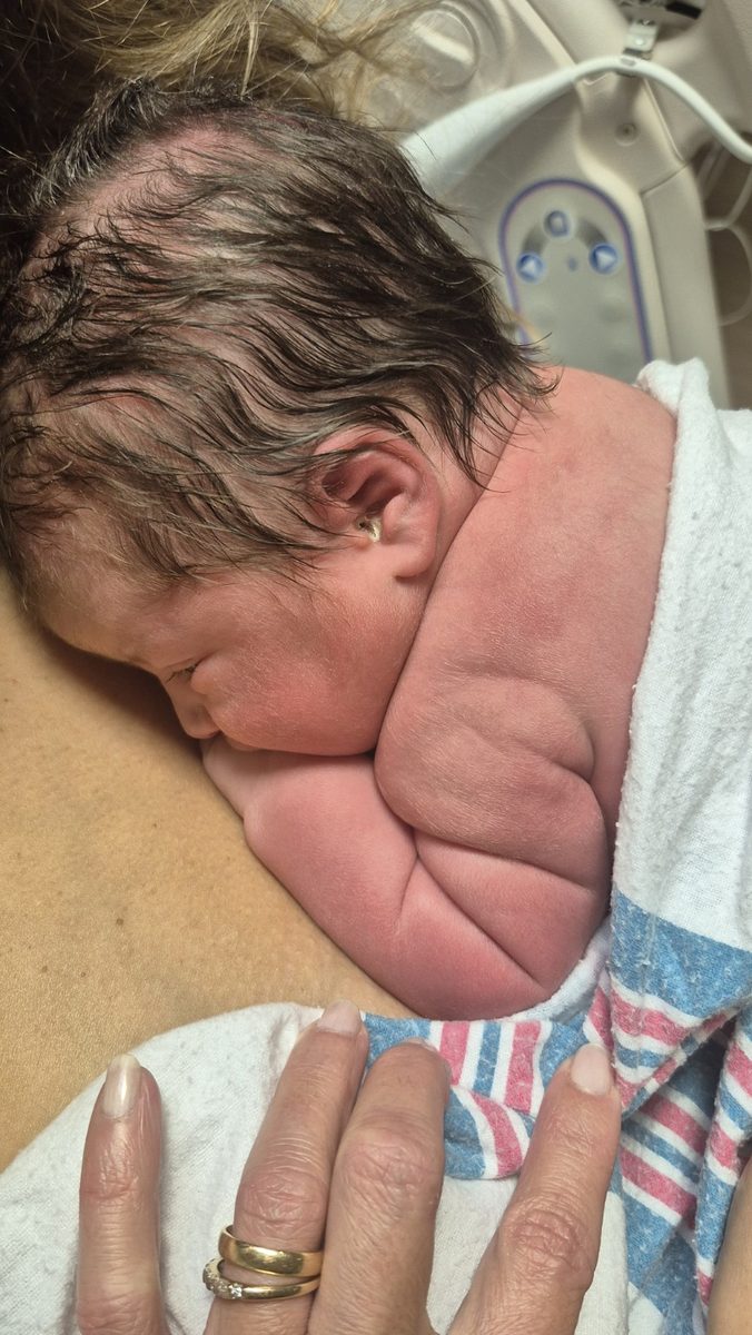 A newborn resting skin-to-skin on a parent's chest